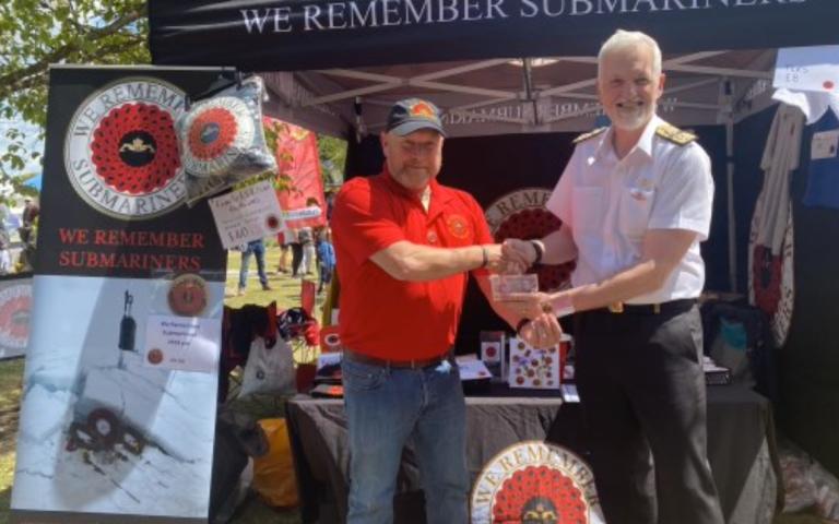 Mick Dewhirst and Paul Dunn shaking hands in front of WRS stand at Collingwood