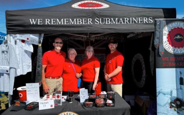 Volunteers under the WRS gazebo with merch in front