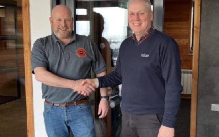 Chairman of WRS Mick Dewhirst shaking hands with a man in a blue pullover