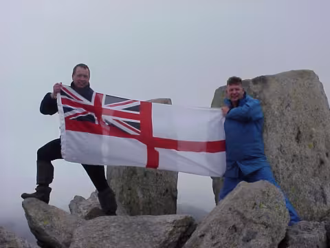 Paddy with a white ensign at the top of a mountain