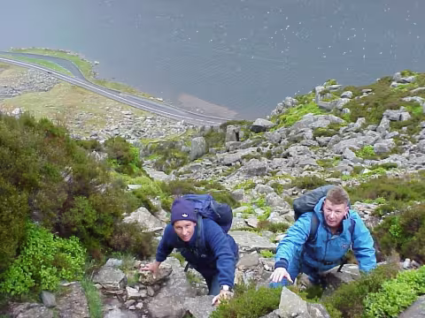 Paddy and another male climbing a mountain