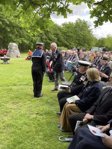 Official passing a wreath to a Sea Cadet with audience watching on © Leigh Dodds