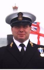 Ian Atkinson, the rudder of an SSN and a fluttering white ensign in the background