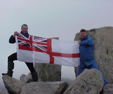 Paddy with a white ensign at the top of a mountain