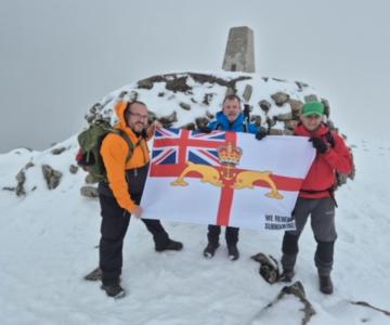 Three Peaks team at snowy summit with WRS ensign