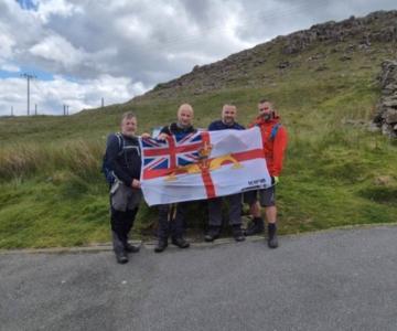 Three Peaks Team (all 4) at roadside hold WRS ensign