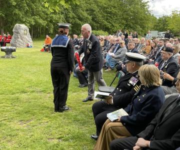 Official passing a wreath to a Sea Cadet with audience watching on © Leigh Dodds